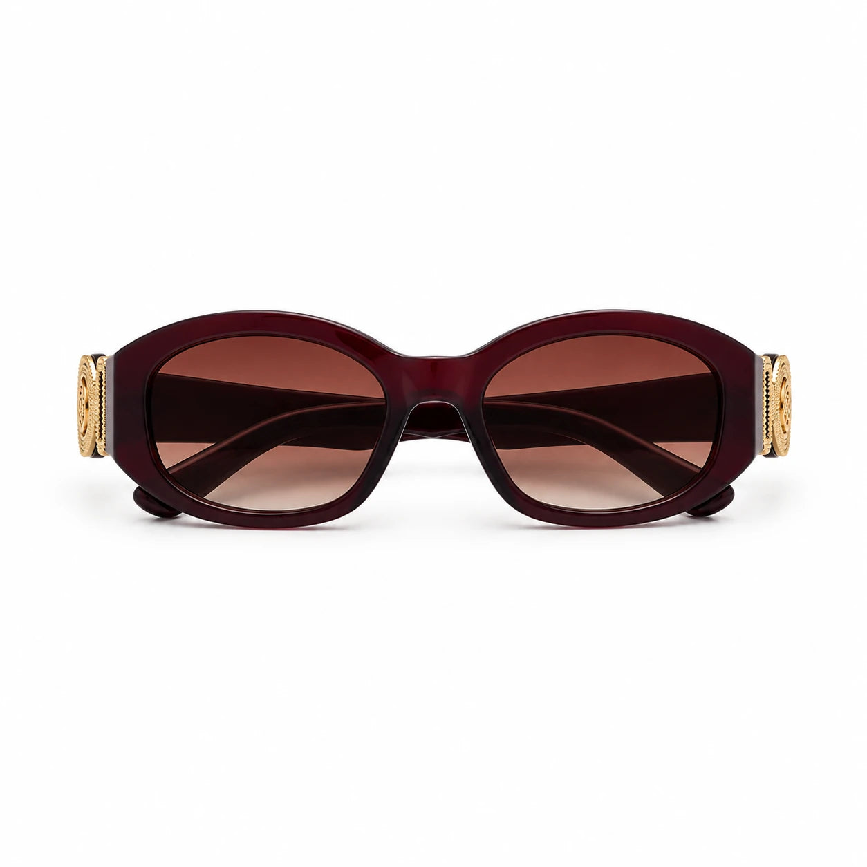 Oval sunglasses with a translucent burgundy acetate frame, brown tinted lenses, and gold decorative hardware on the temples, shown against a plain white background.