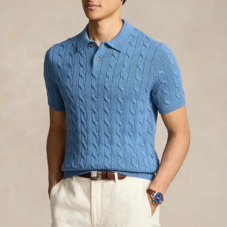 Person wearing a blue cable knit polo shirt against a beige background
