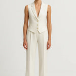 Woman wearing the Monaco Blanc linen suit set with a sleeveless vest and matching trousers, front view