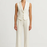 Woman wearing the Monaco Blanc linen suit set with a sleeveless vest and matching trousers, front view