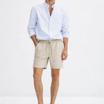 Fez Linen Shorts shown in a lifestyle setting, full length view